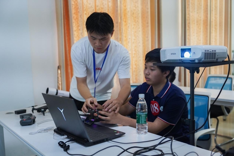 KY开元集团官网入口信息工程学院学生正在指导研学团成员操控无人机。